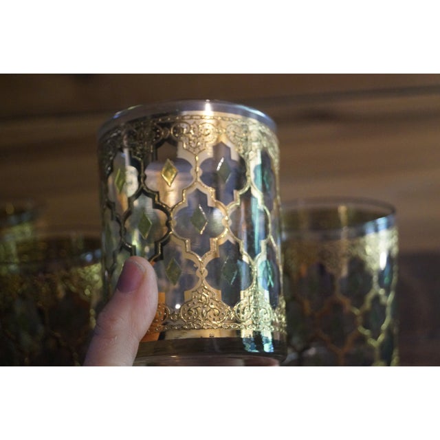 A set of 7 Culver Valencia rocks glasses which have a classic 22 kt gold pattern with green accents. Each measure 4 inches...