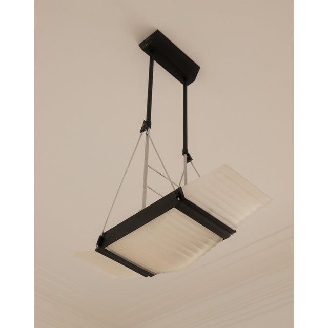 Geometric suspension lamp with murano glass, italy, circa 1960s–1970s. A black rectilinear frame gives the lamp its...