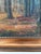 This signed antique original landscape oil painting, from around 1910, shows a forest landscape with a narrow stream...
