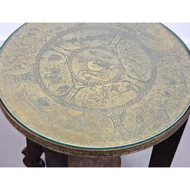This art deco table from the late 1920s has a sports theme going on with etched images of sports like soccer, tennis,...