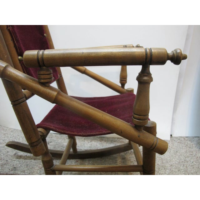 Very sweet, antique, late 1800's children's spindle rocker chair. Walnut wood with red velvet. Measures 27" tall x 14" x...