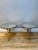 A pair of circular side table in gold gilt wrought iron, with mirrored tops. The tripod legs with spherical feet and...
