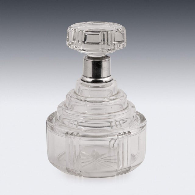 An elegant Art Deco decanter combining finely cut crystal with a silver mounted collar. The decanter features strong...