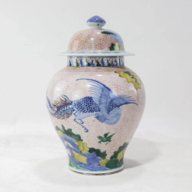 This covered jar exemplifies the refined artistry of late Qing Dynasty Jingdezhen porcelain. The iron-red brocade ground...
