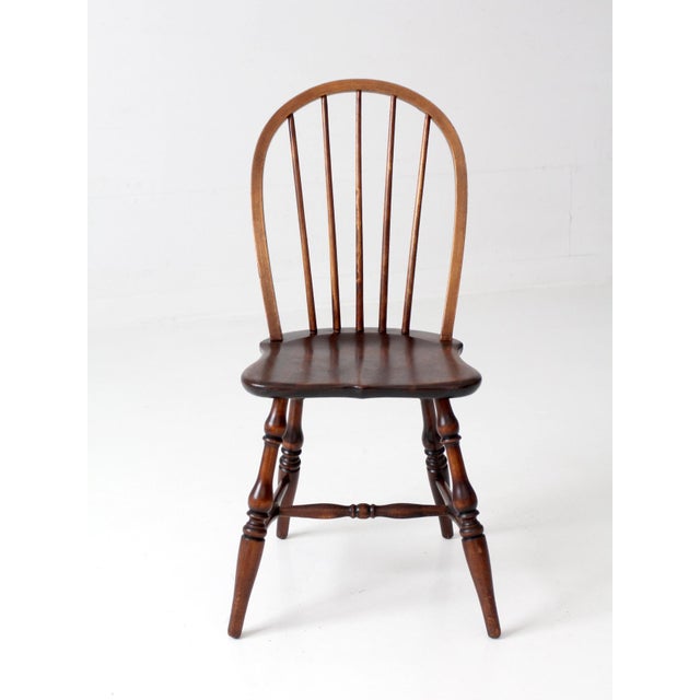 Mid-century Windsor style wood chair with a tall hoop back, slender spindles, shaped seat, and turned legs and stretchers....