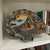 Vintage Satsuma style decorative plate featuring a shell-like shape and a hand-painted scene of figures in a boat. The...