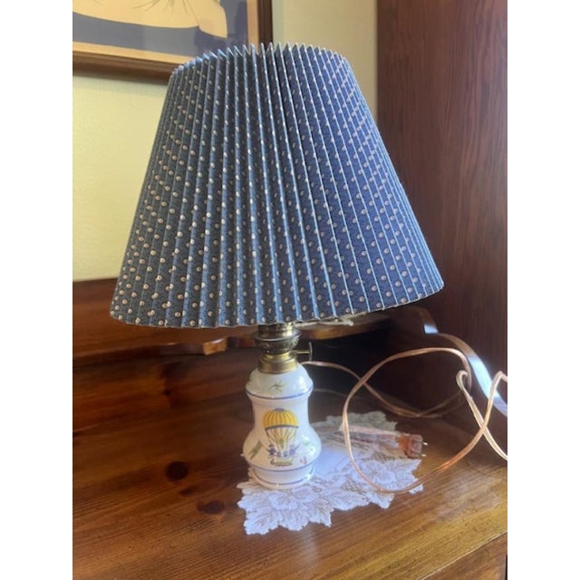 This is a charming vintage-style electric table lamp featuring a pleated blue lampshade with a subtle dotted pattern. The...