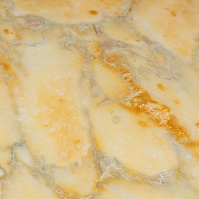 A mid 20th century italian coffee table features an onyx top set on a metal base with adjustable brass feet. Combining...