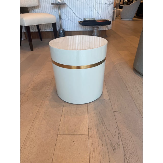 This accent table pairs high-gloss lacquer with rose gold trim for a refined, modern aesthetic. The cream birdseye maple...