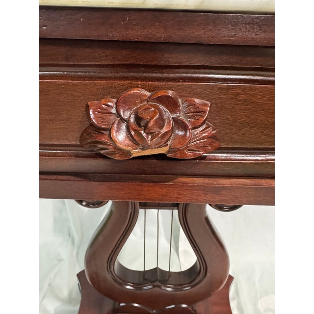 Gorgeous vintage side table with marble top and harp motif. In beautiful condition with some damage to the carved rose...