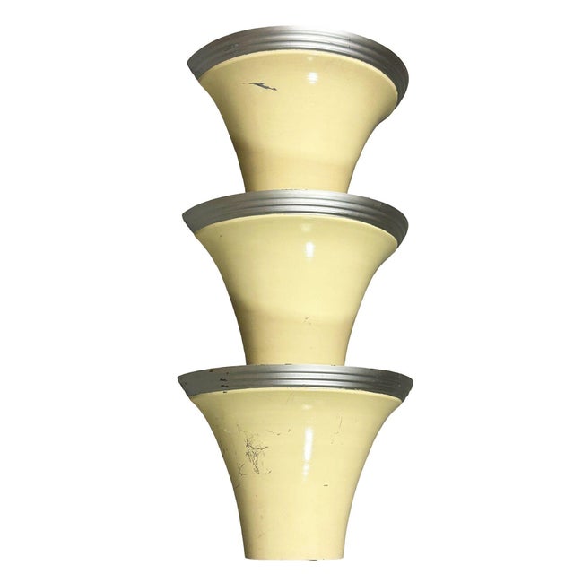 1930 spun aluminum Streamline Art Deco wall sconce featuring a round enameled body with polished trim along the top. These...