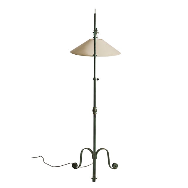 Constructed in wrought iron with a beautifully oxidized verdigris patina, the lamp showcases the skilled metalwork...