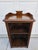 This smaller sized bookcase could double as a bedside table. It has a decorative pediment with an upper lip around the...