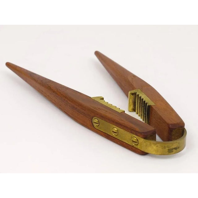 A beautiful Scandinavian modernist nut cracker from the 1950s. Designed by Pool Knudsen. Made of teak and brass. In very...
