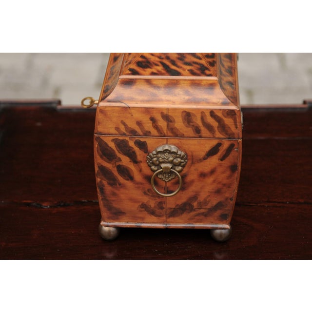 An English Victorian tea caddy from the late 19th century, with faux painted tortoise finish and patinated brass accents....