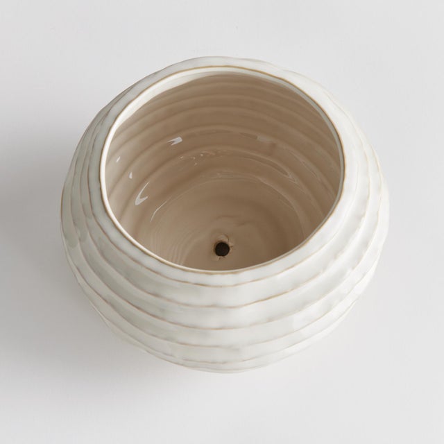 With a reactive glaze and hand finished ribbing detail, this charming pot is a great find. Plant your favorite lush greens...