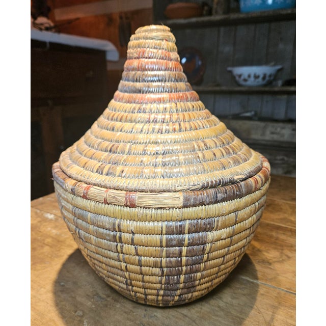 This antique handwoven coiled basket is a striking example of Southwestern Indigenous artistry, likely dating to the late...