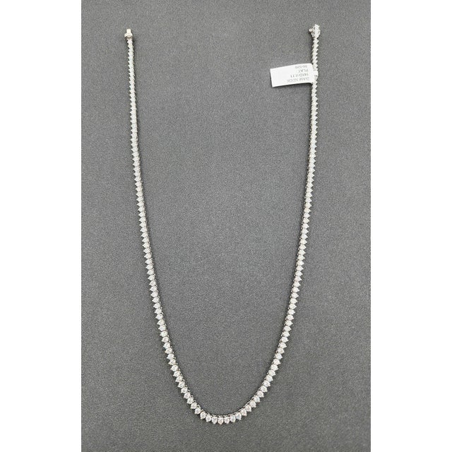 A modern platinum tennis necklace featuring 7.11 carats of natural round-cut white diamonds, with a clarity of VS2/SI1 and...