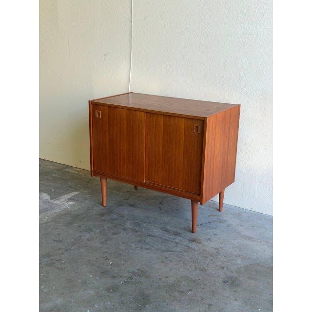 Elegant Mid Century Modern Danish sideboard crafted in warm teak wood, featuring classic Scandinavian proportions and a...