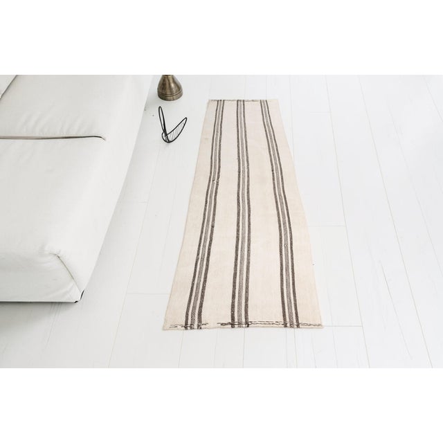 This is a vintage Turkish Oushak rug from the Mid 20th Century. The piece was hand-knotted.