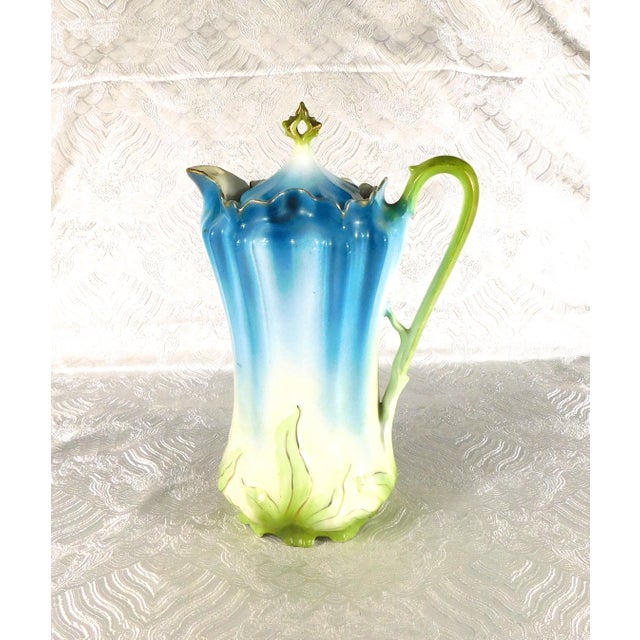 This is an unmarked Chocolate pot. It is teal at the top which fades to white with a light mint green raised leaf design...