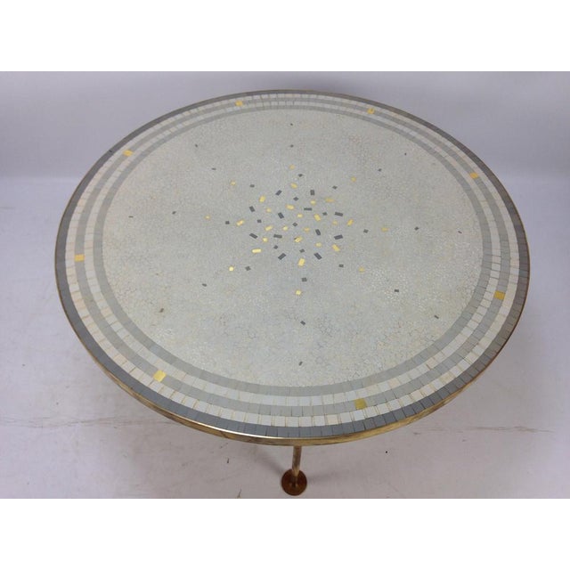 Beautiful round Mosaic top coffee table by Berthold Muller. Brass band around it on three legs. The top has a stunning...