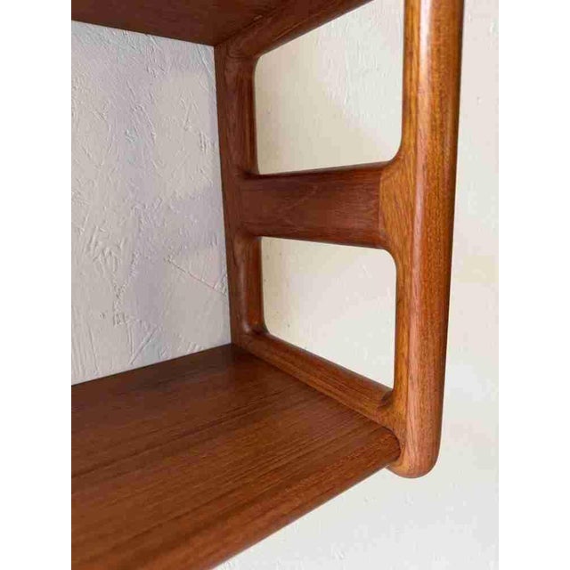 Mid-century wall rack produced by the Danish firm Dyrlund in the 1960s. The design stands out due to the open sides of...