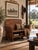 An antique buggy seat bench with a beautifully shaped wood seat, tall back, and sweeping iron supports retained from its...