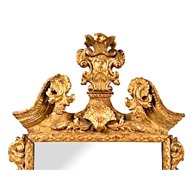 George II Giltwood Mirror. Mirror features beveled edges and is mounted in a gilt frame. Carved with scrolling acanthus...