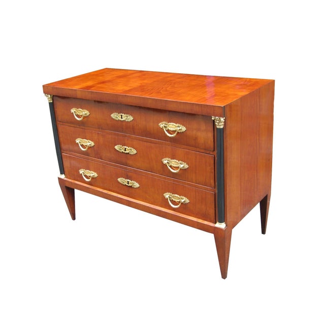 An important pair of neoclassical three-drawer commodes. Cherrywood with ebonized pilasters, patinated bronze pulls,...
