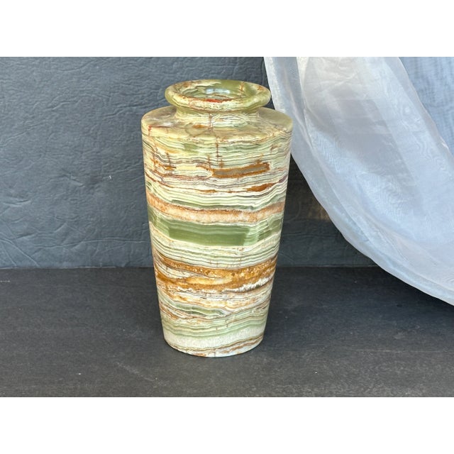 Hand sculpted from one piece of banded onyx, this vintage stone vase is an amazing decorative item. Banded onyx stone is...