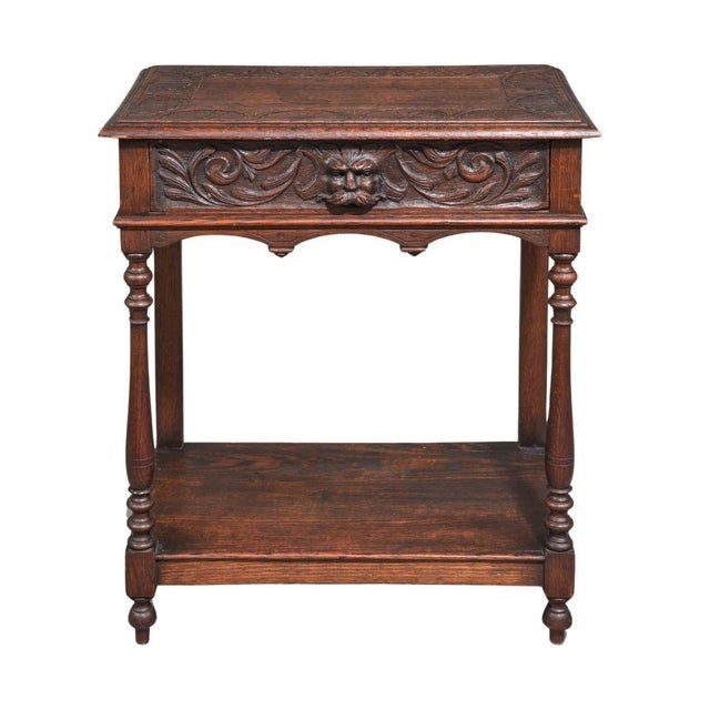 This charming British carved oak table from the 1920s highlights timeless craftsmanship and functional design. The single...