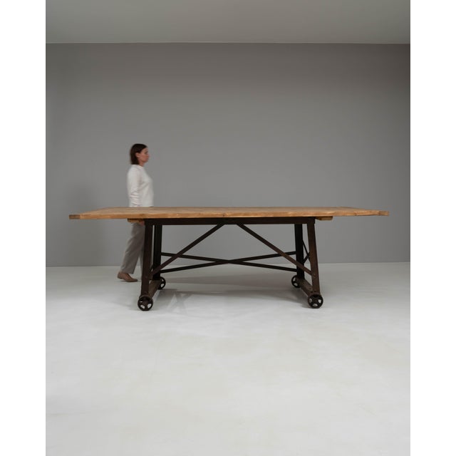 This 1900s French industrial table embodies functionality and timeless design. Featuring a solid wood top with a rich,...