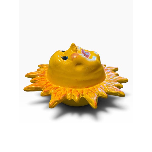 Bring a dose of sunshine and personality to your walls with this whimsical ceramic sun face wall plaque. The sculptural...