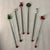 These items are vintage hand-blown lampwork glass Christmas swizzle sticks, featuring festive holiday toppers like a tree,...