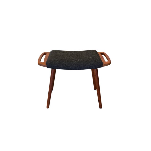 Danish vintage stool in teak with softly rounded handles and a slightly bowl-shaped, upholstered seat. The openwork...