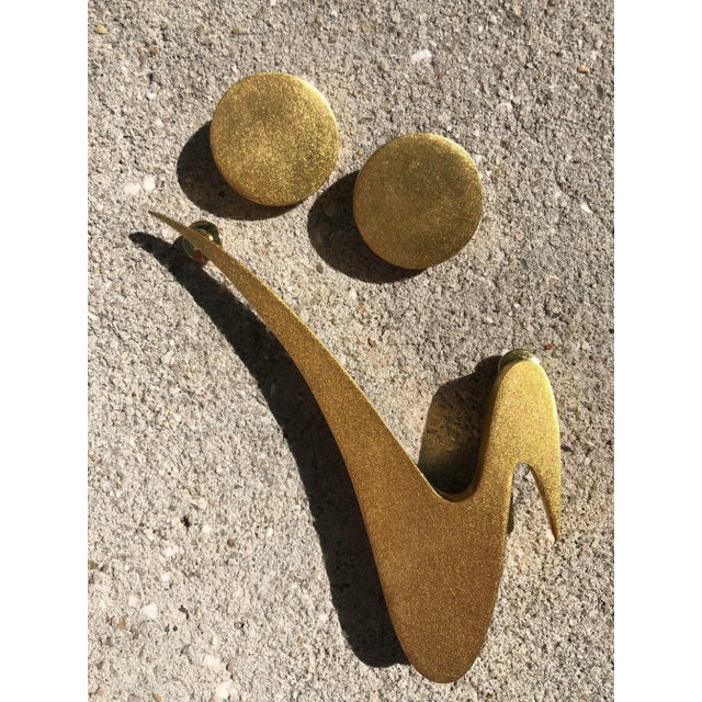 Fabulous set of clip earrings, in a gold disc style, and an oversized, lightning bolt-shaped brooch. Signed by the artist....