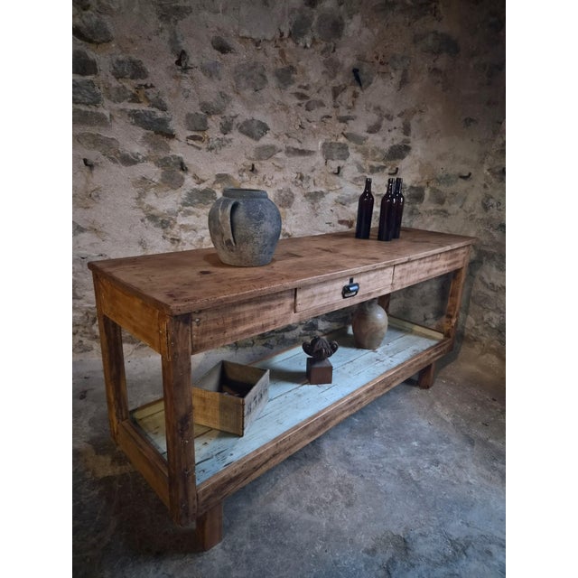 Antique French draper’s table dating from circa 1920–1940, constructed from poplar and pine with a fruitwood top....