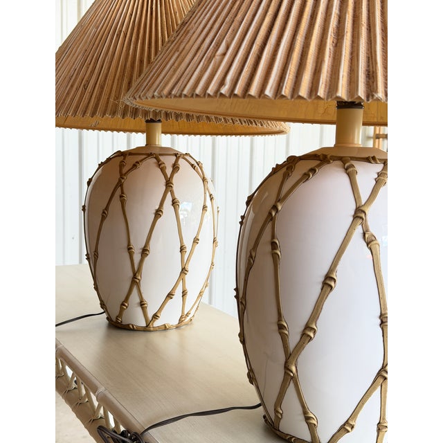 An exceptional pair of vintage Hollywood Regency table lamps featuring the highly sought-after “icing” faux bamboo...
