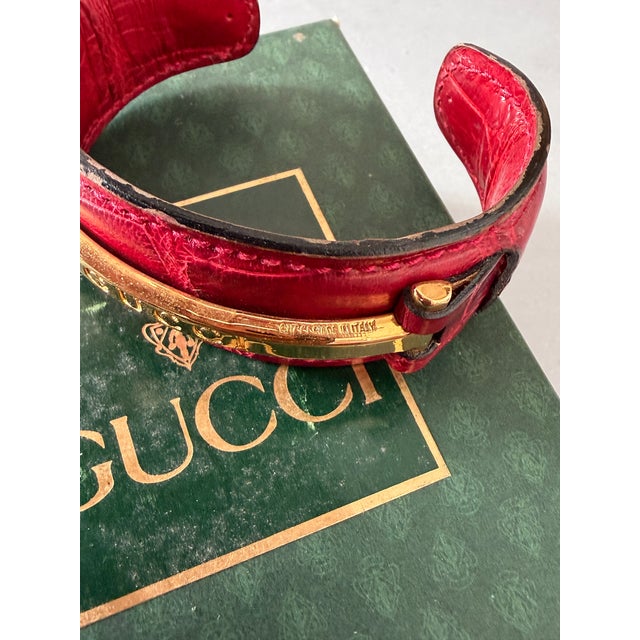 Vintage 1990's Gucci open cuff bracelet in red crocodile style leather with the iconic Gucci gold tone narrow horse bit...