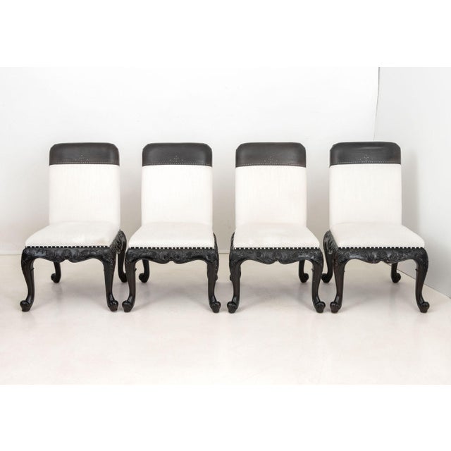 Set of Four Ralph Lauren "Bel Air" Dining Chairs, each with white linen and black leather upholstery above ebonized wood...