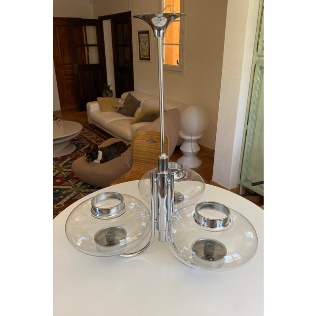 Stunning 1970s Space Age design three-arm chandelier. Chrome-plated metal frame and hand-blown glass globes. This is an...