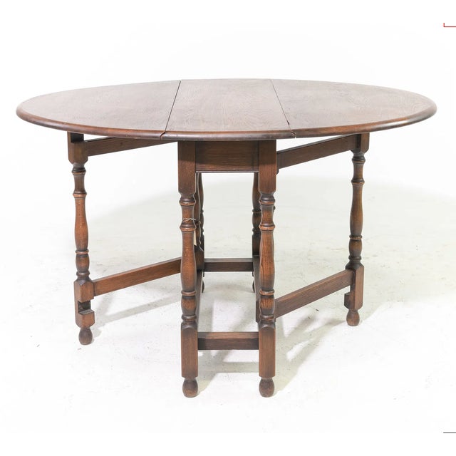 Hand-turned legs in the traditional English or Jacobean Revival style and the narrow central top with two hinged leaves...