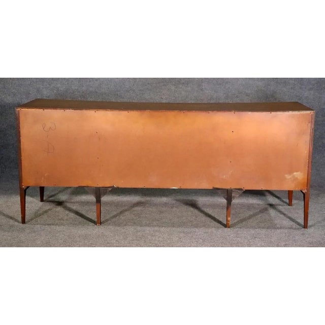 Vintage walnut dresser by Unagusta with curved front. Nine total drawers, sculpted front doors and tapered legs. *** No...