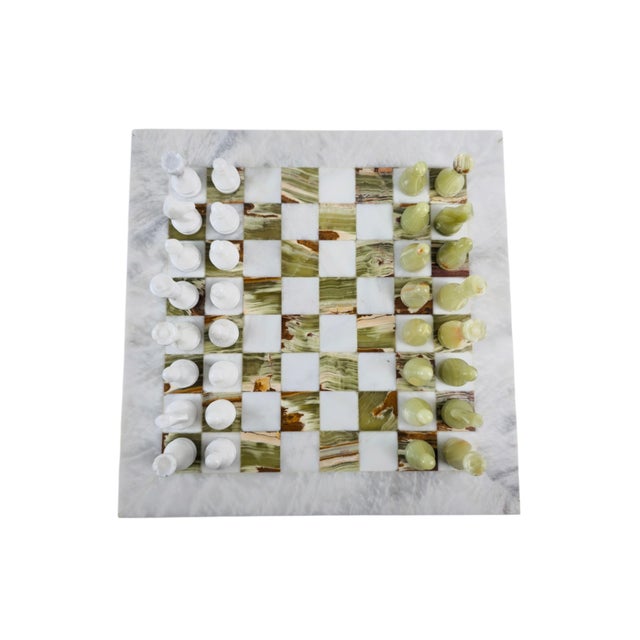 A decorative chess set with a board of white and green marble/onyx. The playing surface consists of alternating white and...