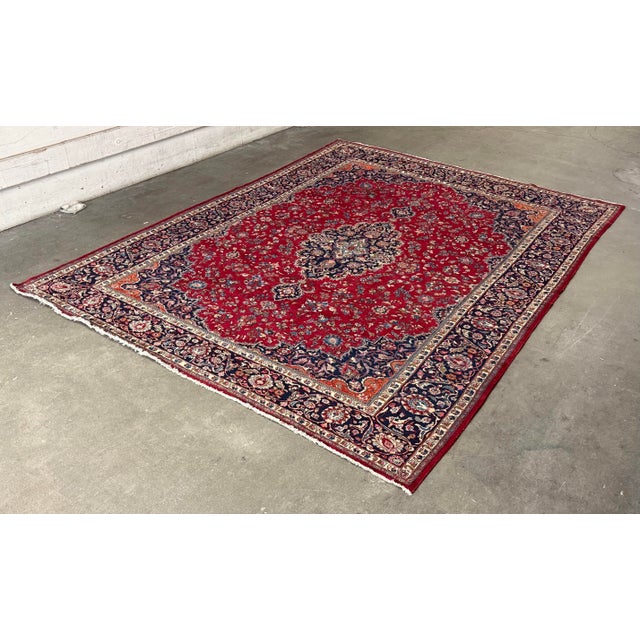 Design Plus Gallery presents a 11ft 4 in × 15ft 6 in Persian Kashan Handmade Wool Rug. This traditional rug displays an...