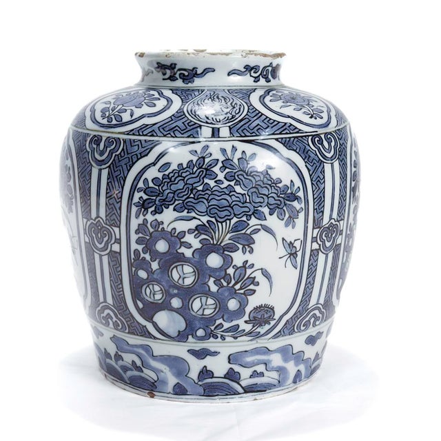 A fine antique Dutch Delft vase or jar. The body decorated with cartouches of stylized peony bouquets on a latticework...
