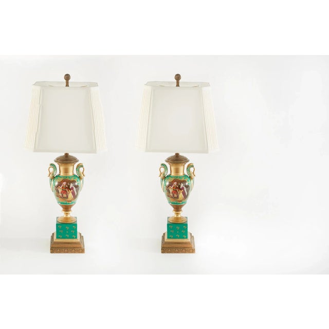 19th century pair of gilt porcelain urn shape with exterior romantic scene design details table / task lamps. Each lamp is...