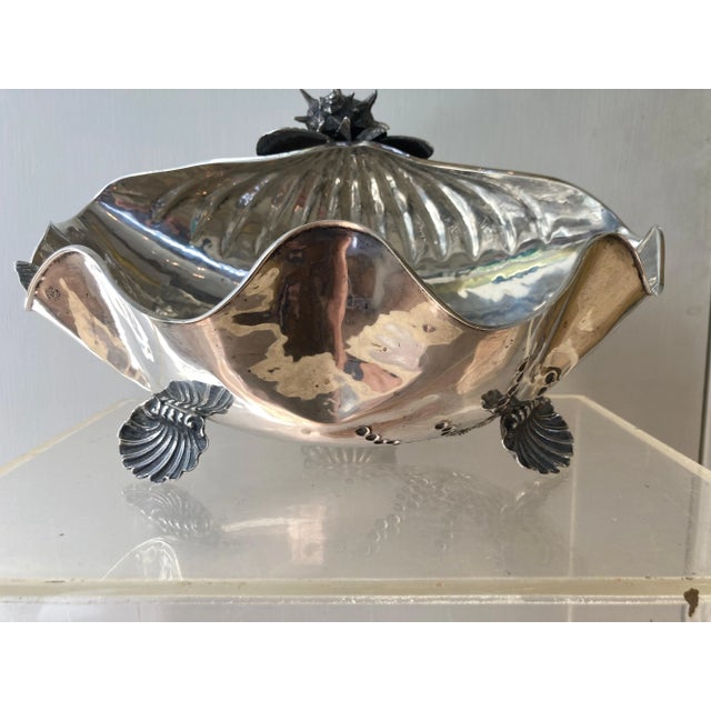 An exceptionally beautiful grotto style sterling silver conch shell embellished with additional shells on a tripod base of...
