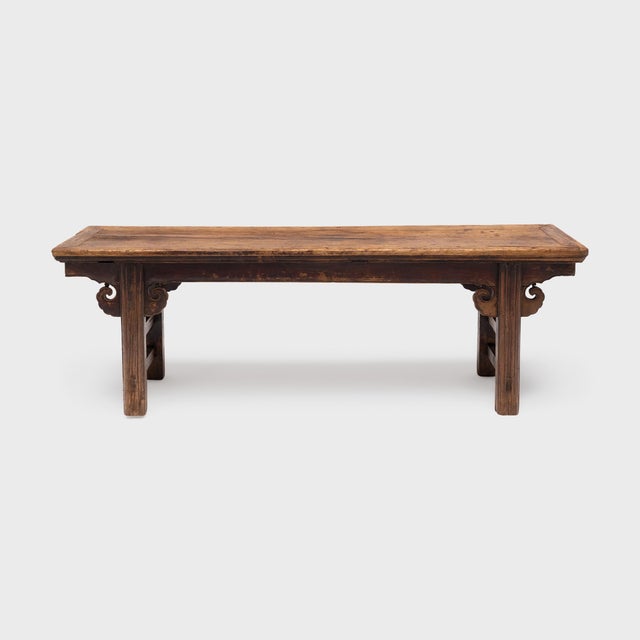 This antique Chinese bench follows the classic recessed-leg form, defined by its inset legs linked with straight...